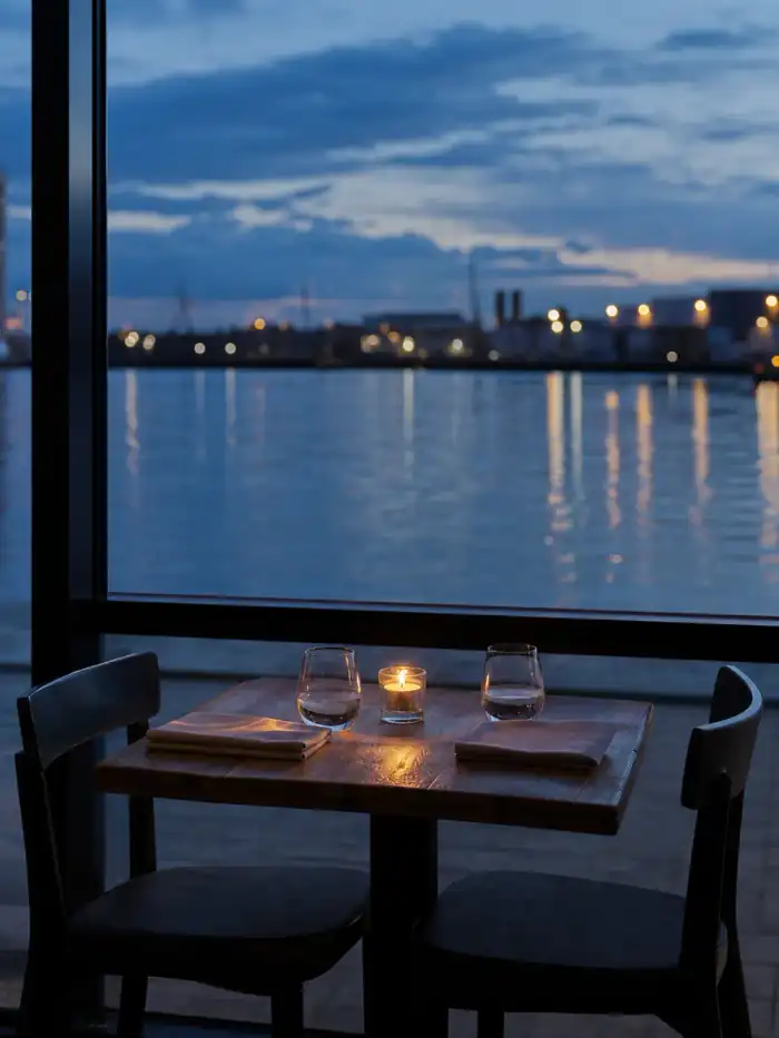 Tafel voor twee naast het raam met rivierzicht.
